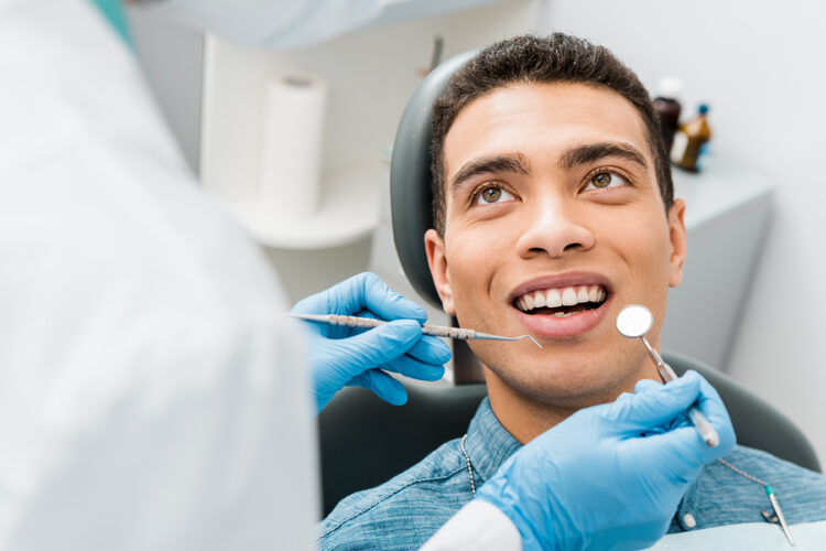 Cheerful African American man during examination in dental clinic.